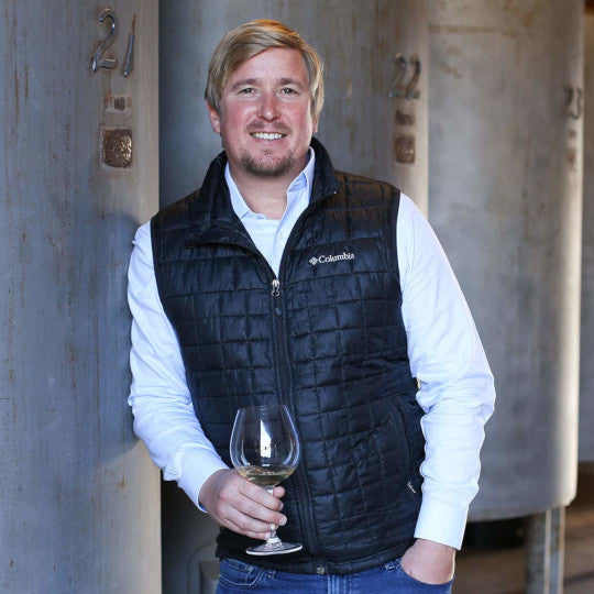Ian Cauble holding a wine glass in the cellar